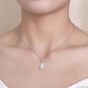 Close-up of 1.5ct pear-cut moissanite pendant necklace on neck, elegant silver jewelry.