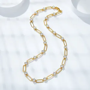 Detail of gold-plated paperclip necklace with round Moissanite stones on white background.
