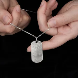 Primer plano de un colgante de placa de identificación de moissanita sobre fondo negro