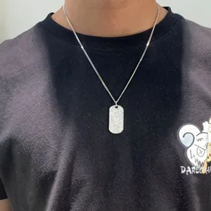 Detalle del collar con colgante ovalado de moissanita para hombre en camiseta negra