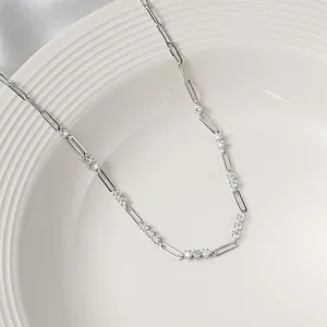 Close-up detail of silver paperclip necklace with 3mm moissanite stones