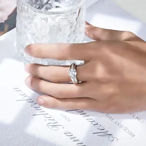 Detalle de un anillo de moissanita de 2 quilates en plata 925 en la mano de un modelo.