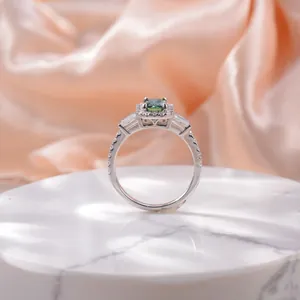 Detailed side view of 5x7mm emerald cut green moissanite ring with halo setting.