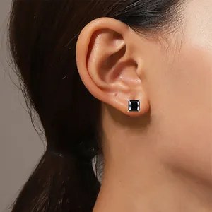 Primer plano de un pendiente de moissanita negra con corte princesa en la oreja