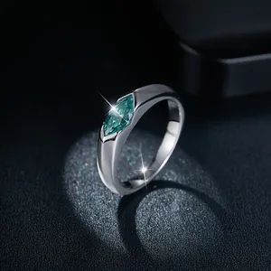 Macro view of a marquise-cut teal moissanite gemstone in a sleek silver ring band.