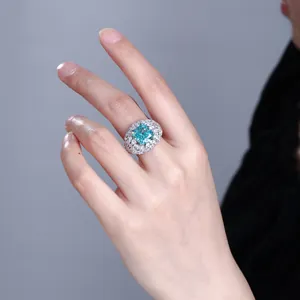 Detailansicht eines luxuriösen Ringes mit blauem Edelstein am Finger, S925 Silber