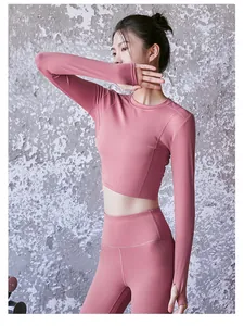 Vista laterale del crop top rosa a maniche lunghe e leggings che mostrano la vestibilità.