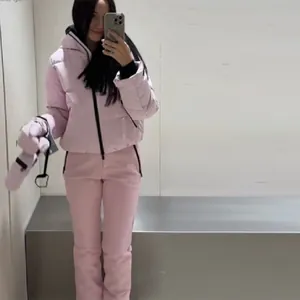 Women's pink hooded ski suit set with warm padded jacket and pants for winter sports.