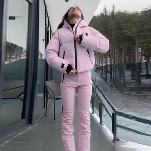 Detailed view of women's pink hooded ski suit set with puffer jacket and pants