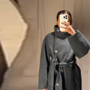 Dettaglio dell'elegante collo alto e della vita con cintura su questo cappotto grigio