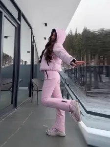 Stylish pink hooded winter ski jacket and pants set for women in snowy outdoors