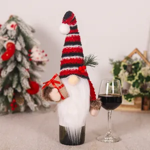 Dettaglio di un copribottiglia di vino a forma di gnomo natalizio con cappello a righe