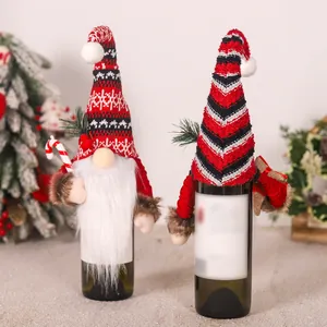 Dettaglio di copribottiglie di vino gnomo di Natale con cappelli a maglia e bastoncino di zucchero