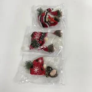 Dettaglio di tre gnomi natalizi confezionati in plastica con accessori a tema