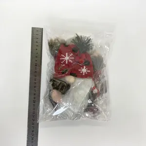 Dettaglio di un peluche di gnomo di Natale con misurazione della taglia vicino al righello