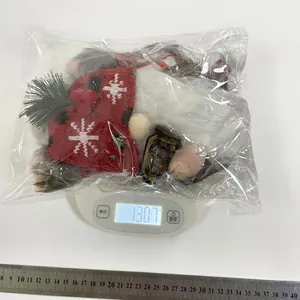 Dettaglio di uno gnomo di Natale di peluche che pesa 130,7 g su una bilancia