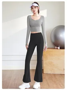 Femme portant un crop top gris à manches longues et un pantalon de yoga noir évasé