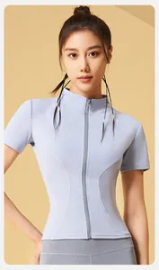 Detailed view of women's slim-fit light blue athletic zip-up top for running and yoga