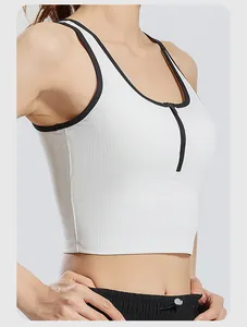 Primo piano di gilet da yoga a coste bianco con zip nera e bordo a contrasto.