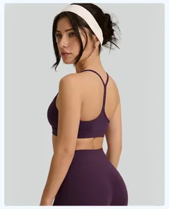 Detail back view of purple high-impact sports bra with thin straps and a white headband