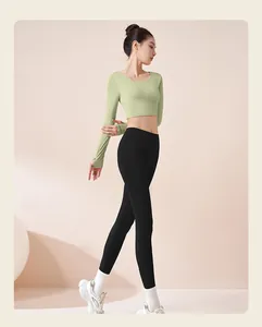 Modella con crop top verde chiaro a maniche lunghe e leggings neri da yoga a vita alta