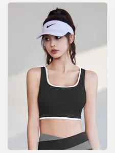 Model wearing a black high-stretch sports bra with white trim in an outdoor setting