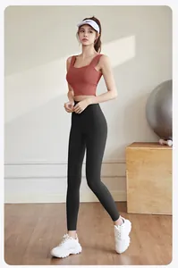 Detailed view of women's terracotta yoga top and black leggings for gym fitness