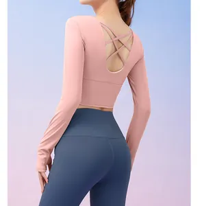 Detail showing the elegant criss-cross back design of this pink long-sleeve yoga top.