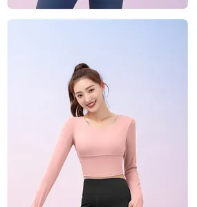 Close-up of a fit model wearing a pink long sleeve yoga top and black leggings