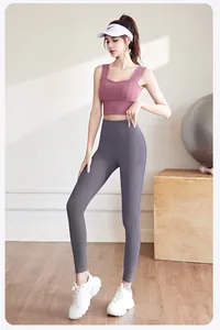 Detail view of pink sports bra and grey high-waisted yoga leggings on model
