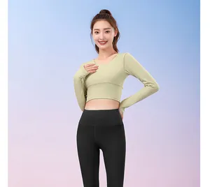 Asian model wearing light green long sleeve crop top and black high waist yoga leggings
