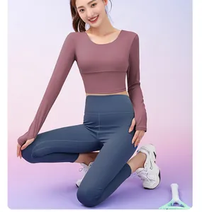 Close-up of a woman in a mauve long sleeve yoga top and high-waist blue leggings