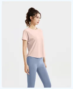 Side profile of pink short-sleeved mesh sports top and high-waist blue yoga leggings
