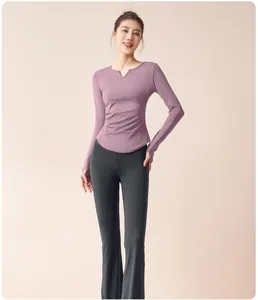 Schmal geschnittenes lila Yoga-Top mit V-Ausschnitt und schwarzer Schlaghose am Modell