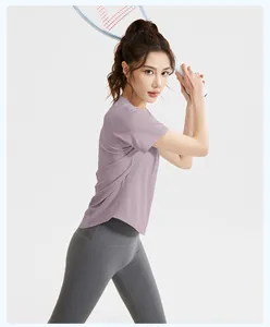 Side view of woman in purple t-shirt and grey leggings holding a tennis racket