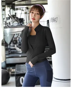 Modella asiatica con giacca sportiva nera e leggings blu in un centro fitness moderno