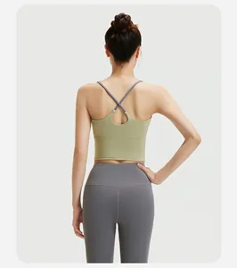 Achteraanzicht van olijfgroene sportbeha met kruisbandjes en grijze yoga leggingset