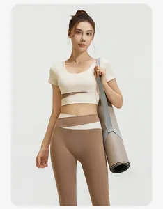 Professionelles asiatisches Model trägt ein beiges und braunes elastisches Yogaset