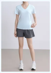 Detalle de un top deportivo azul claro con cuello en V y shorts de running gris oscuro