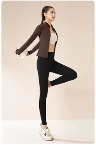 Modèle asiatique portant un ensemble de yoga doublé polaire avec un ballon de fitness
