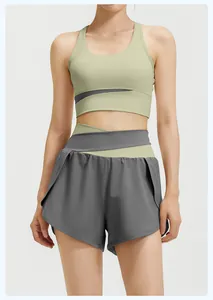 Close-up of premium women's two-piece yoga set with green sports bra and grey shorts