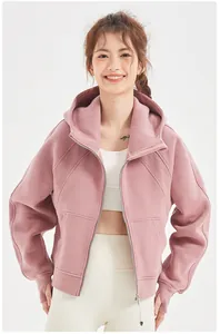 Détail d'un sweat à capuche zippé surdimensionné rose poudré avec doublure polaire chaude.