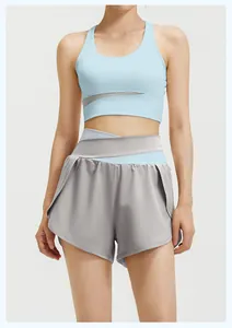 Front detail of women's yoga set featuring light blue sports bra and grey crossover shorts.