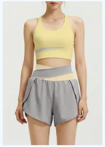 Detailed view of women's yellow sports bra and grey layered waist yoga shorts set