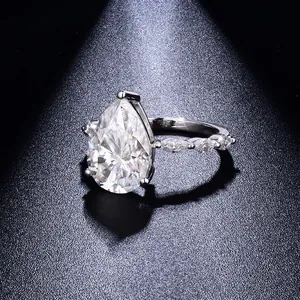 Macro view of pear cut moissanite ring with brilliant fire and marquise side stones