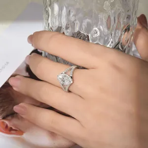 Close-up detail of a marquise-cut moissanite engagement ring on a woman's hand