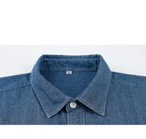 Detail of blue cotton denim shirt collar showing white button and fabric texture