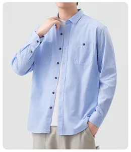 Detailopname van een lichtblauw casual herenoverhemd met lange mouwen in denimstijl