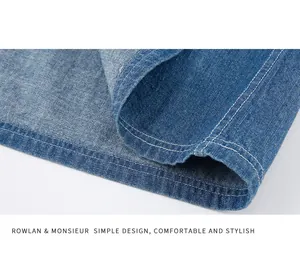 Close-up of double-stitched hem on a blue cotton denim shirt showing fabric texture.