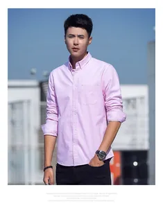 Close-up detail of a men's light pink long-sleeve Oxford shirt on a model outdoors